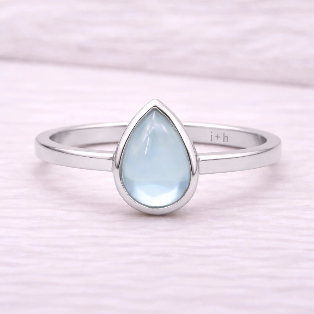 Sterling Silver ring with a teardrop-shaped light blue natural topaz gemstone on a white background
