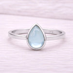 Sterling Silver ring with a teardrop-shaped light blue natural topaz gemstone on a white background