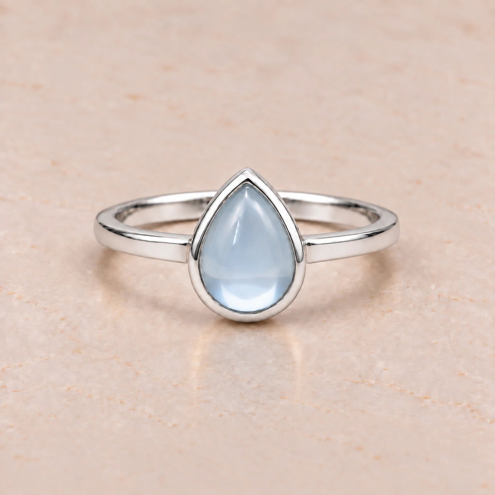 Sterling Silver November birthstone ring with a teardrop-shaped light blue natural topaz gemstone on a white background