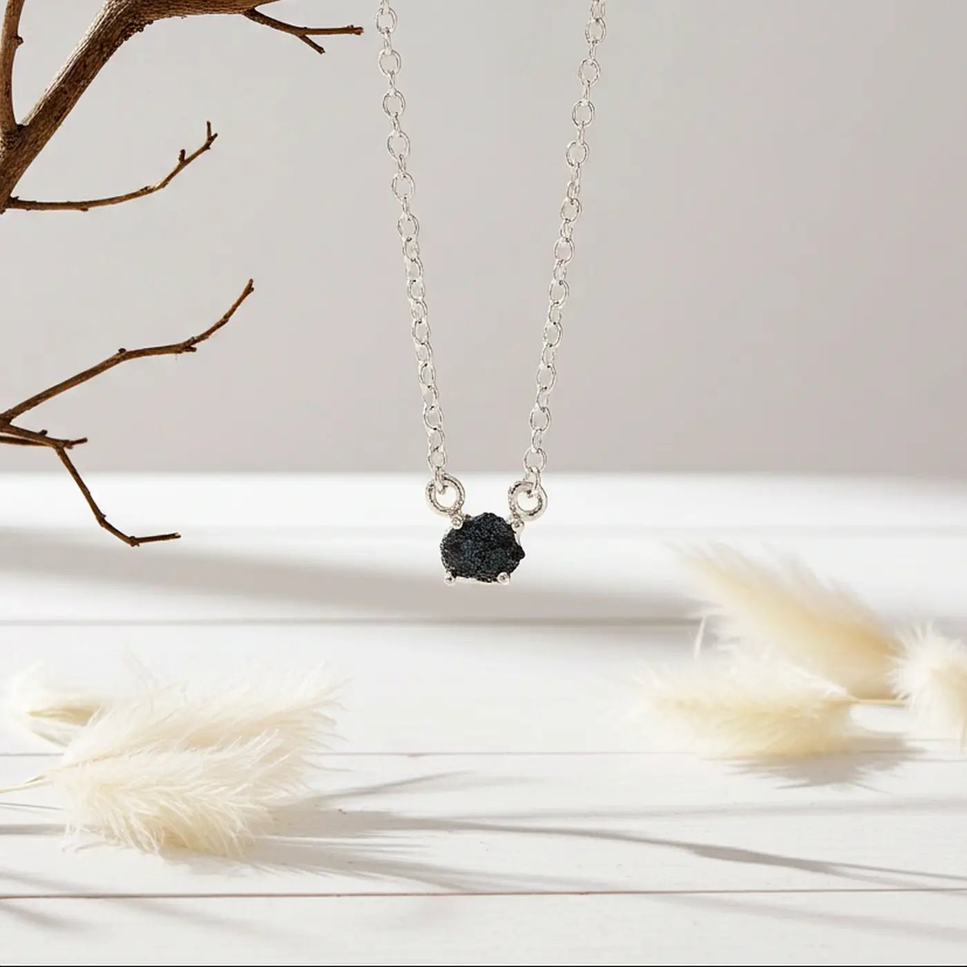 sterling silver Necklace with a raw blue diamond pendant on a white background