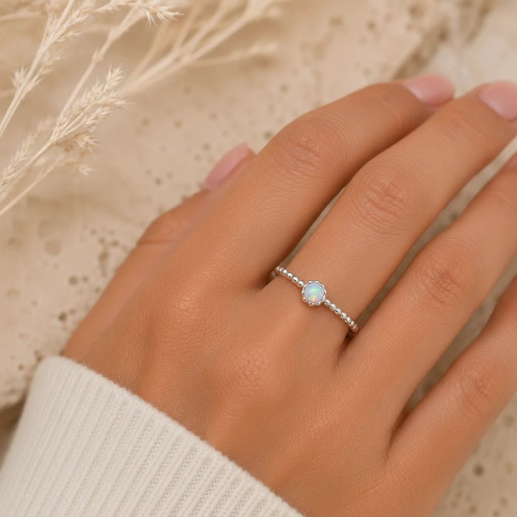 Beaded White Opal Ring with 4 mm round lab-grown white opal in a scalloped bezel on a 925 sterling silver stacker band