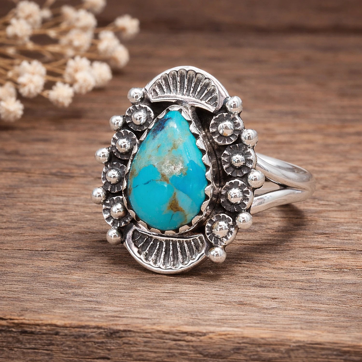 Silver ring with a turquoise stone on a wooden surface