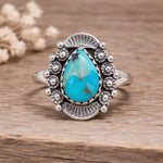 Silver ring with a turquoise stone on a wooden surface