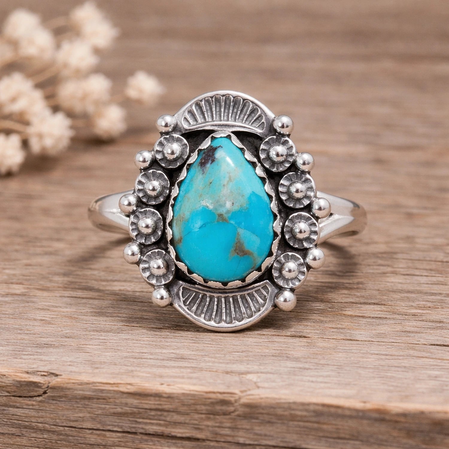 Silver ring with a turquoise stone on a wooden surface
