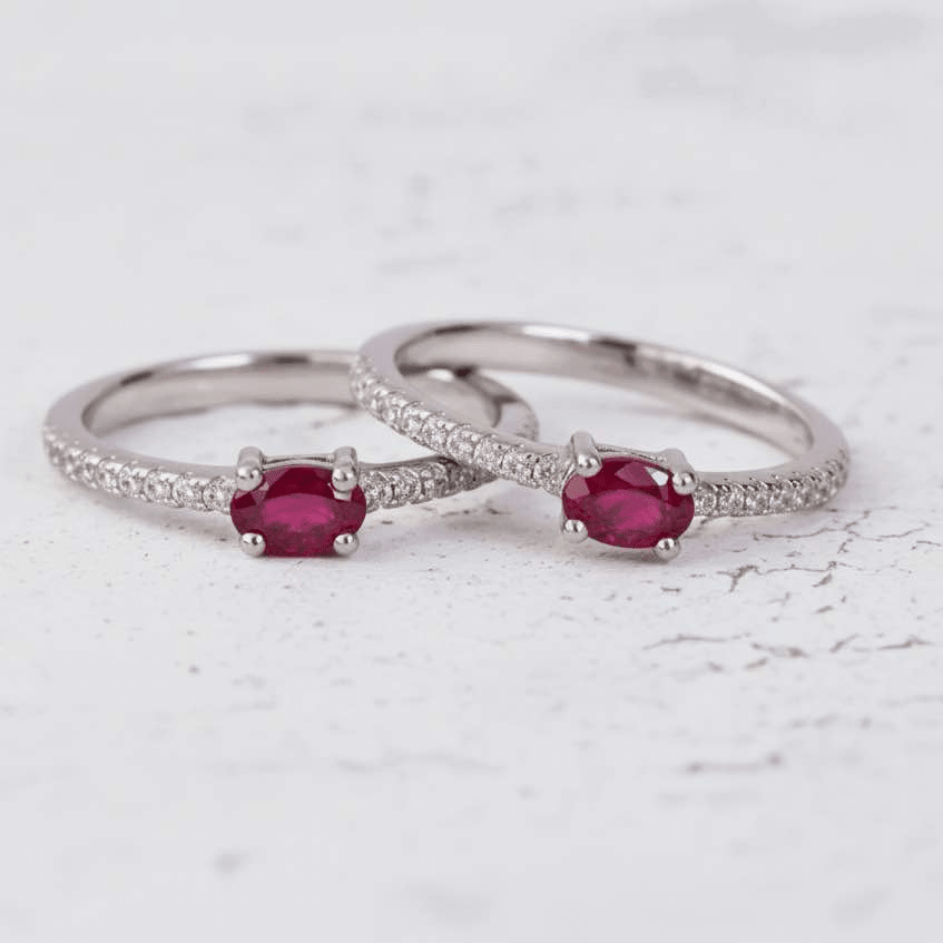 Two sterling silver rings with red ruby gemstones on a white surface 