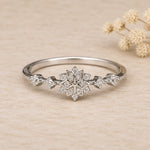 front view of sterling silver snowflake ring with cubic zirconias on a light surface