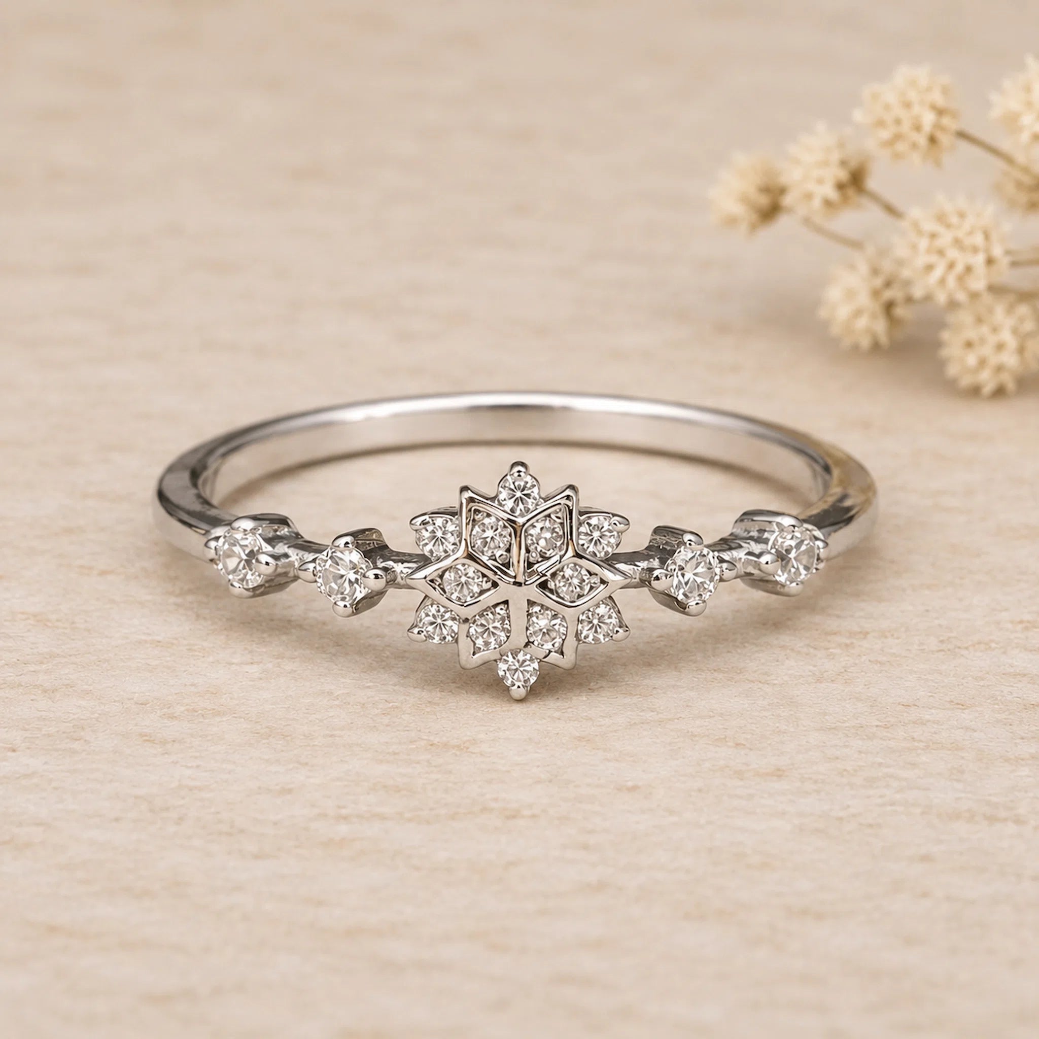 front view of sterling silver snowflake ring with cubic zirconias on a light surface