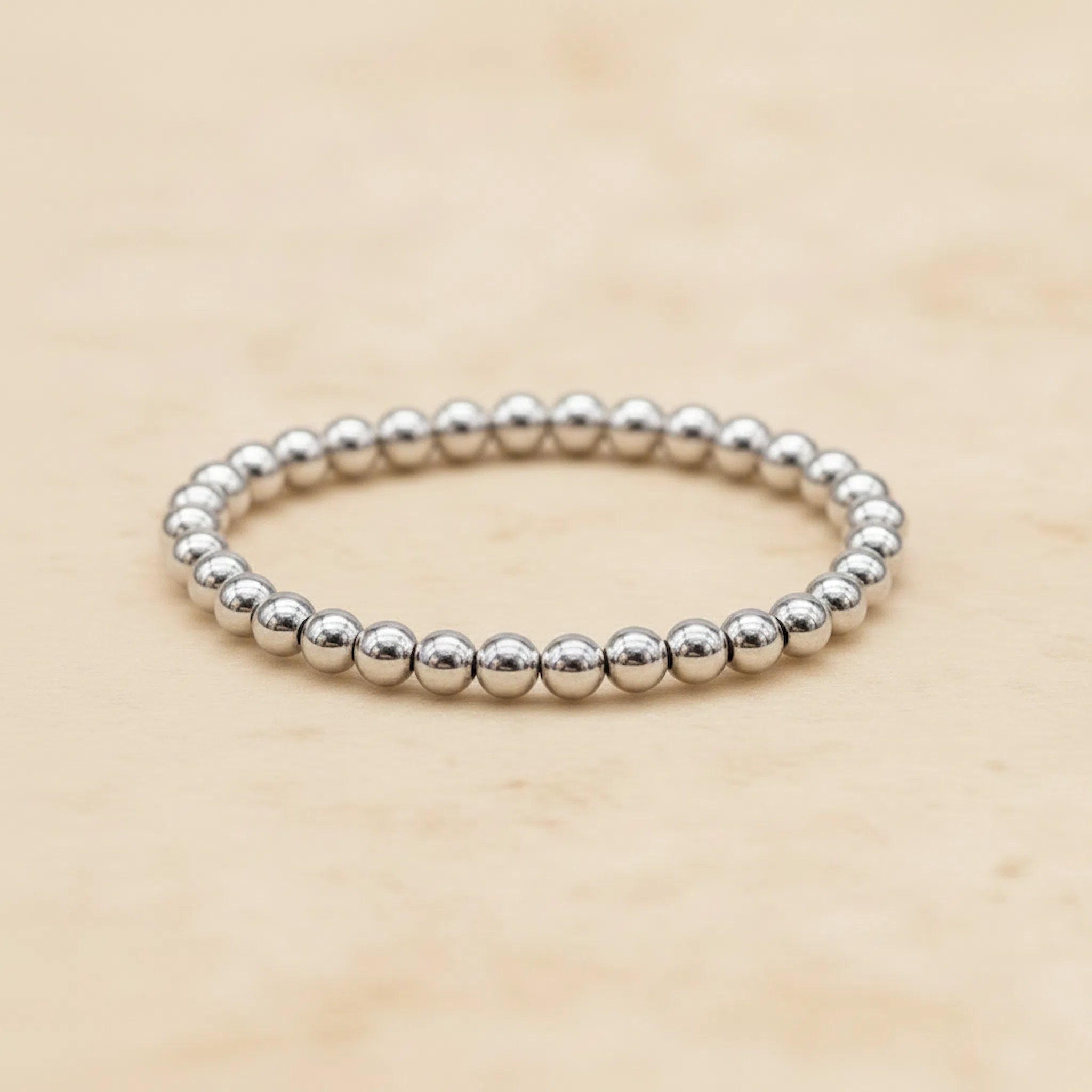 Sterling Silver beaded stacker ring on a beige background