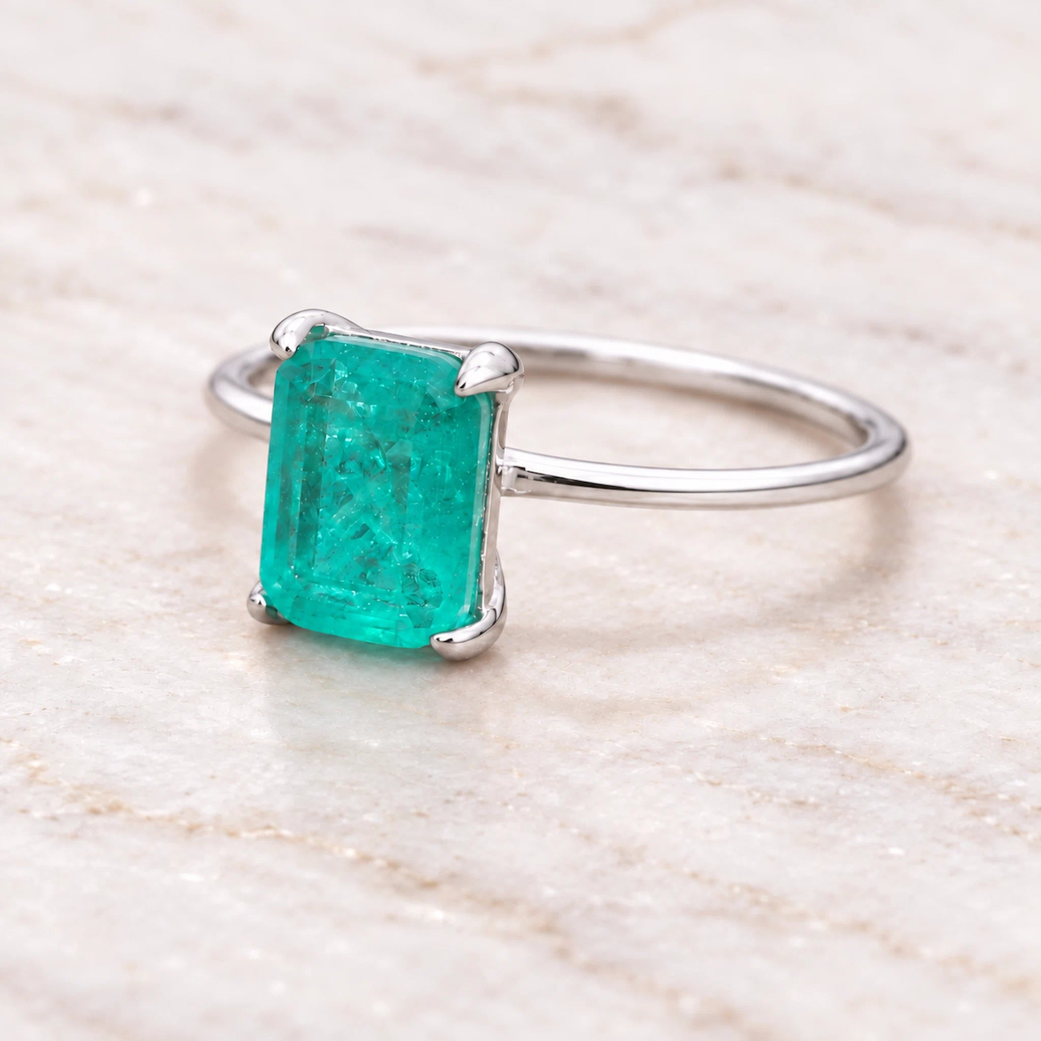 sterling silver ring with a green blue natural tourmaline gemstone on a neutral background