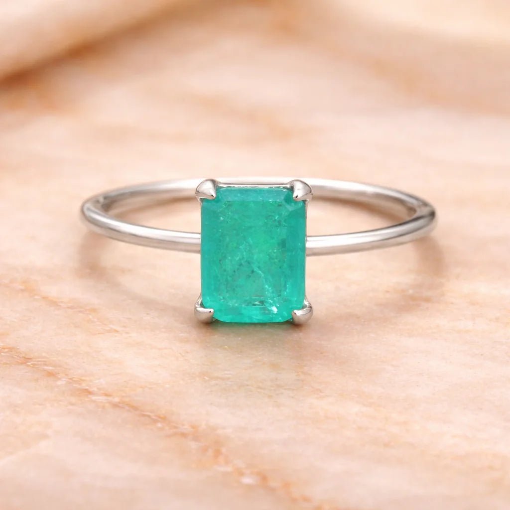 Sterling Silver ring with a natural green blue tourmaline gemstone on a wooden surface