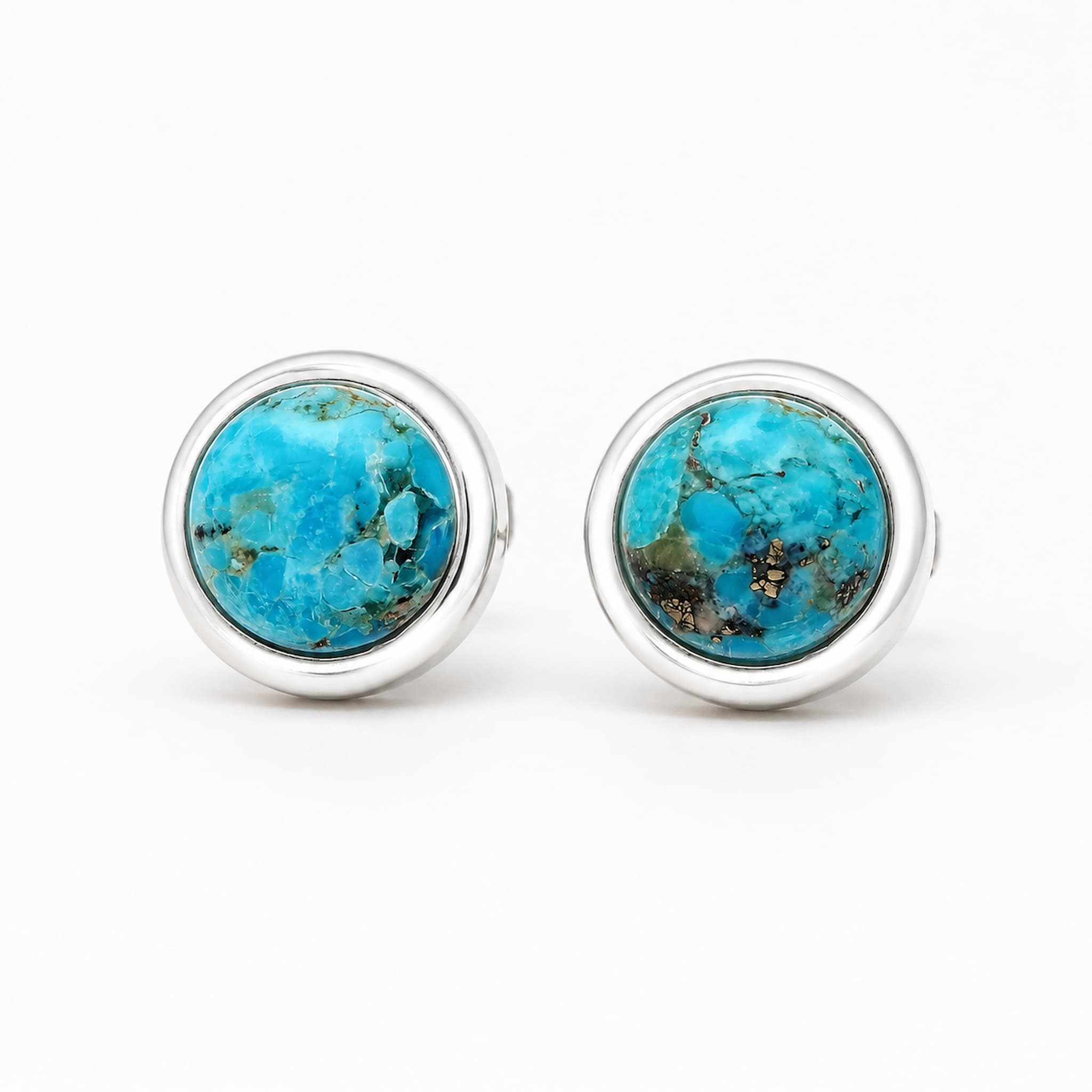 A pair of silver stud earrings with round turquoise cabochon stones, displayed on a clean white background.
