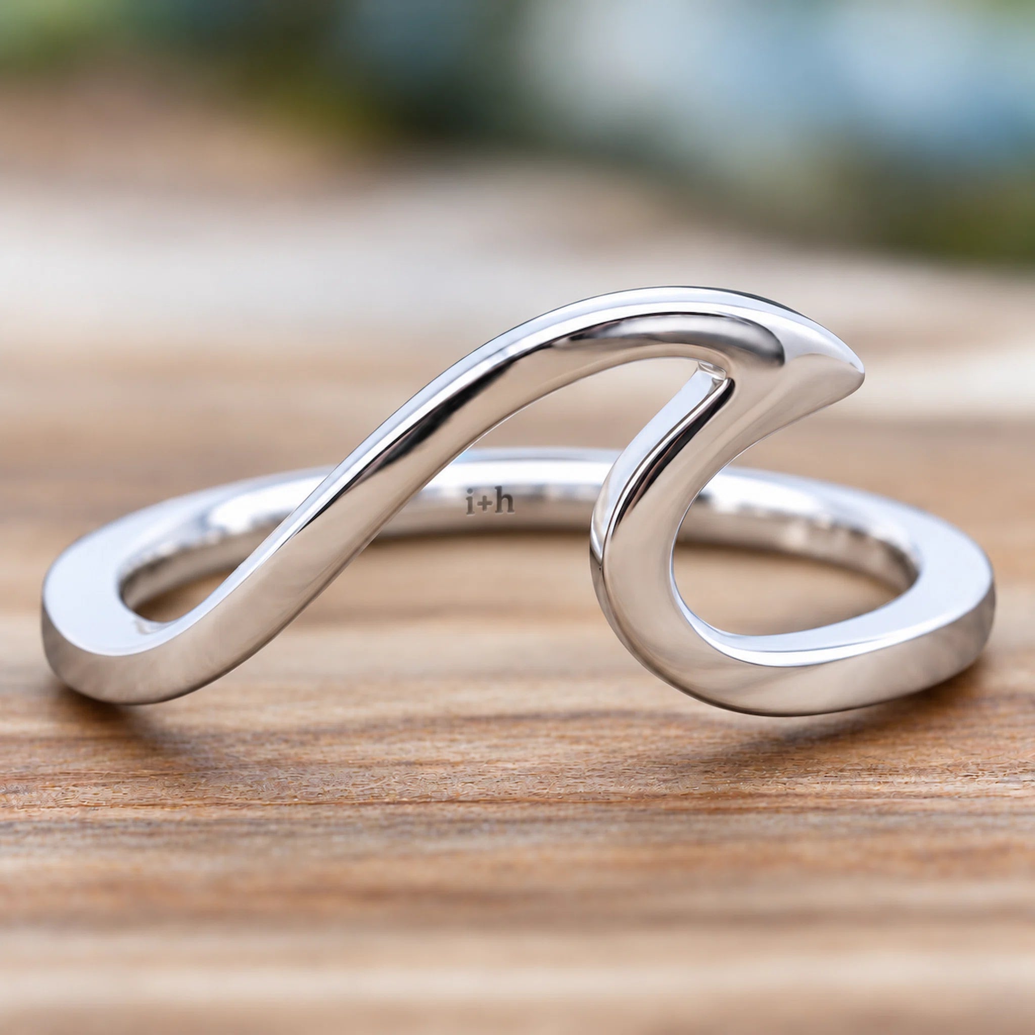 indie and harpers sterling silver wave ring on a wooden surface