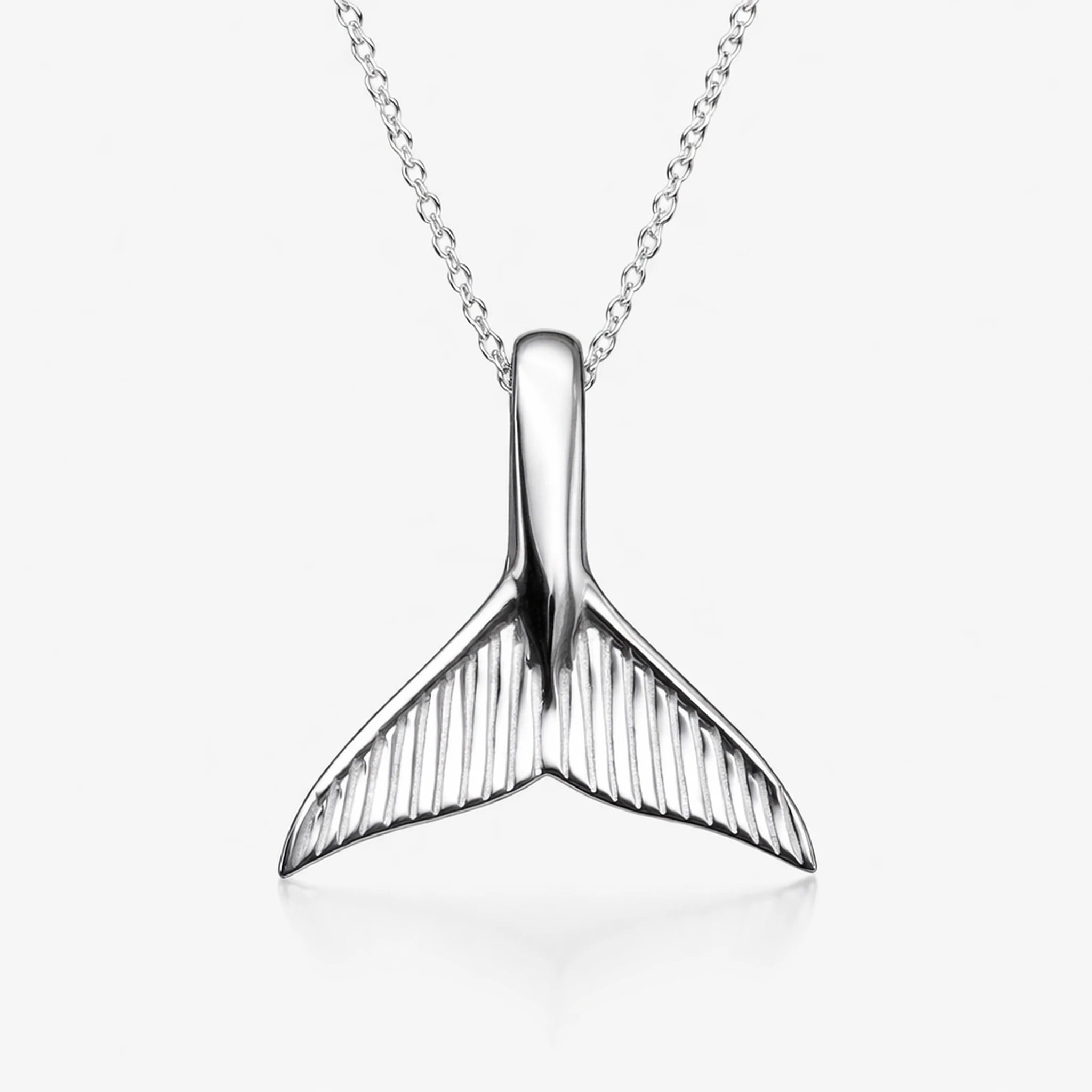 Silver whale tail pendant on a white background