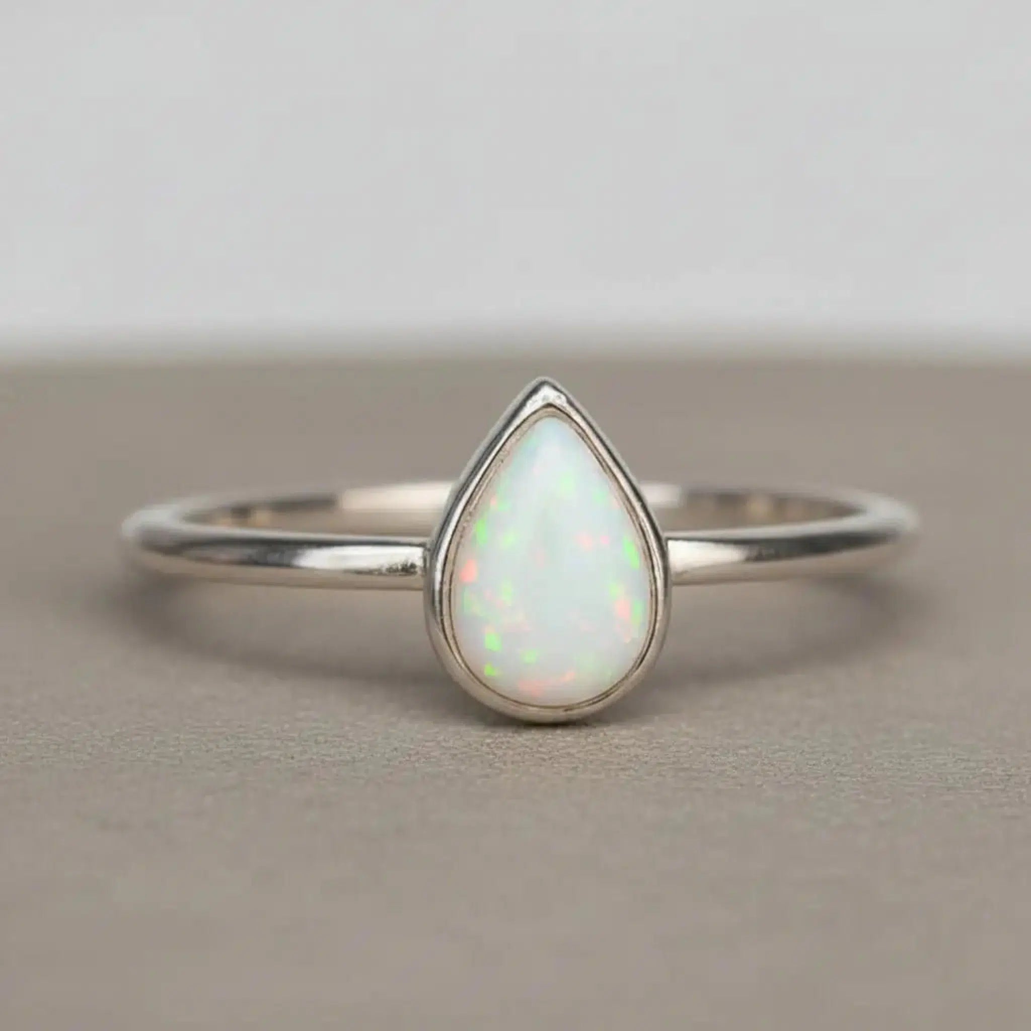 sterling Silver ring with a teardrop-shaped white opal stone on a neutral background