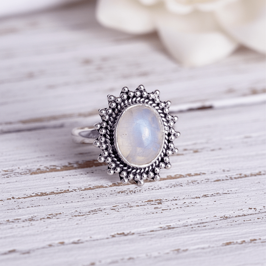 sterling silver rainbow moonstone ring on a wooden surface