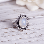 sterling silver rainbow moonstone ring on a wooden surface