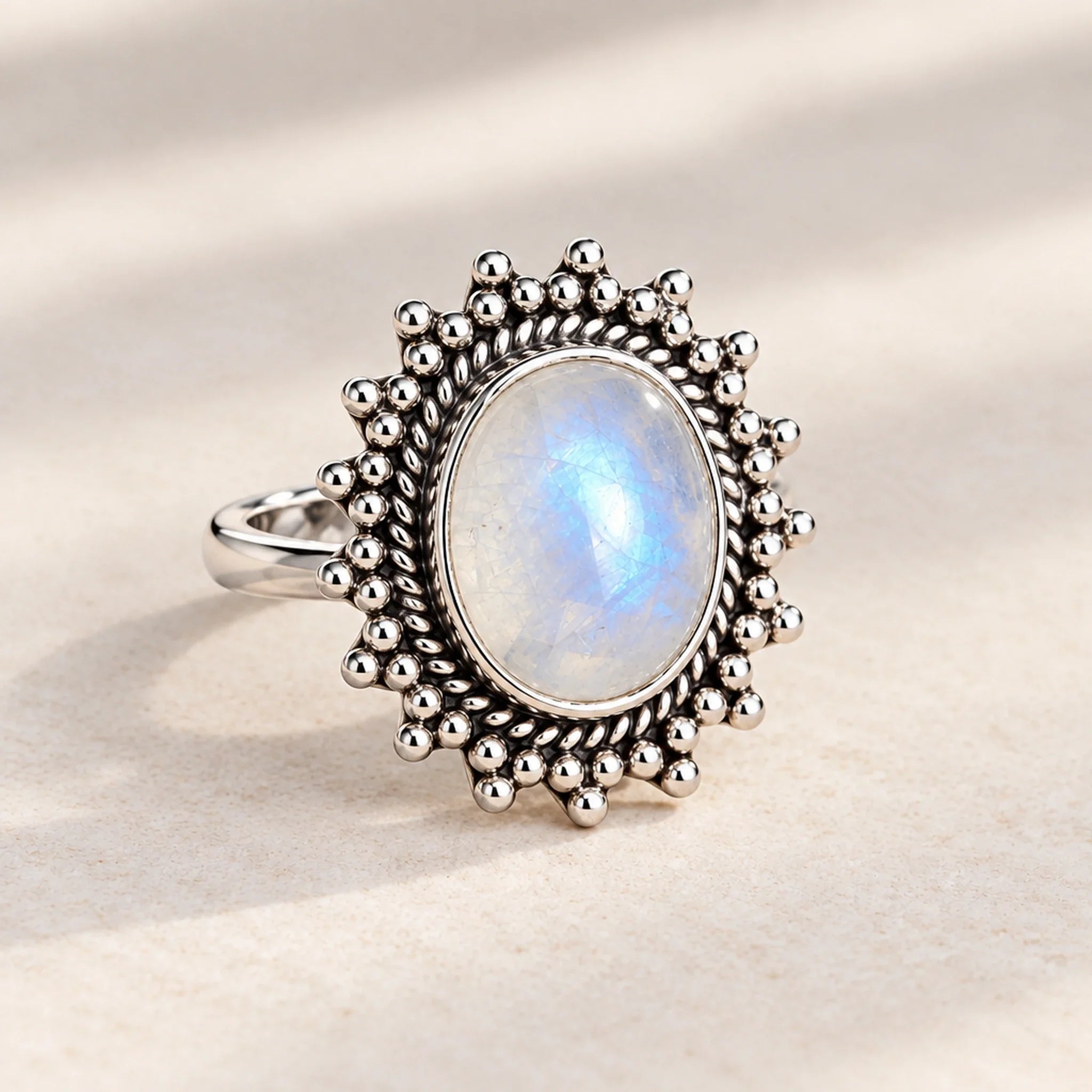 Sterling silver rainbow moonstone sun ring on a wooden surface