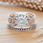 Silver ring with moonstone on a wooden surface