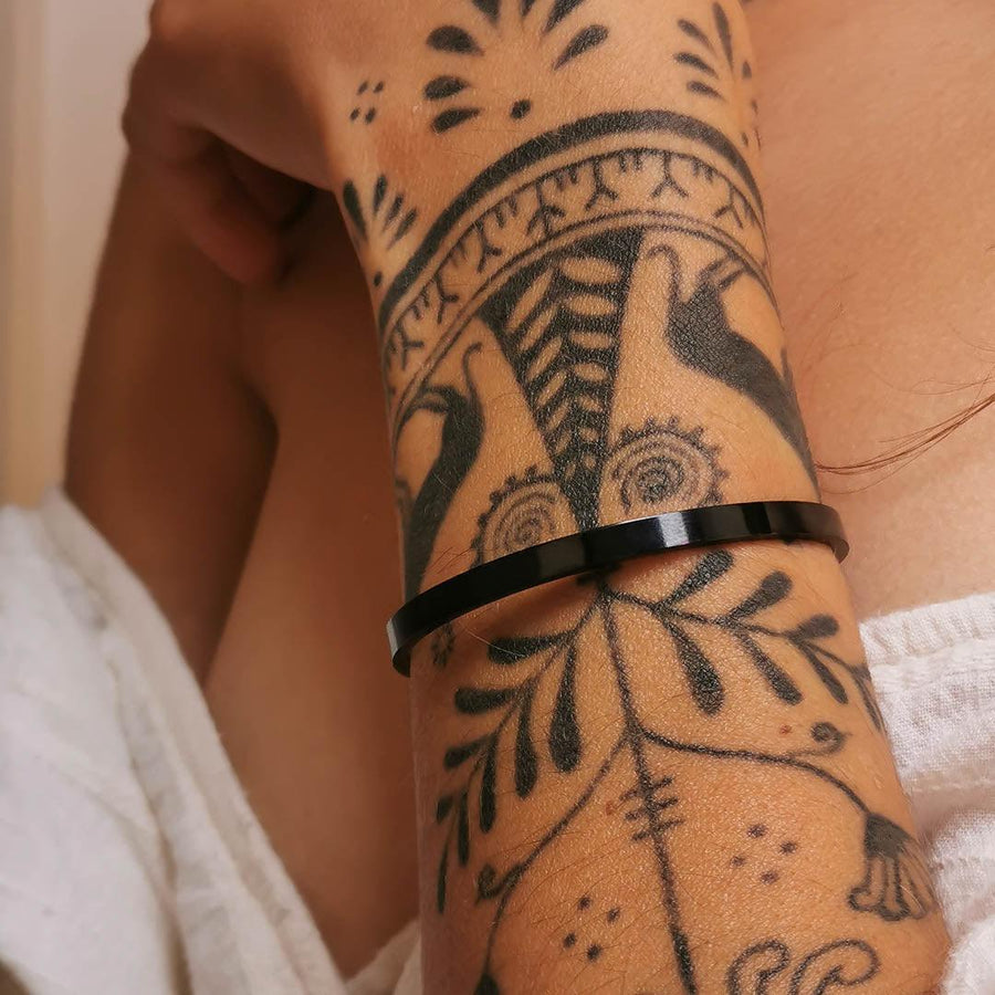 Woman’s arm with black tattoos wearing black Cuff bracelet - womens black jewellery australia