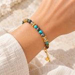 Turquoise and labradorite gold bracelet worn on wrist with extender chain