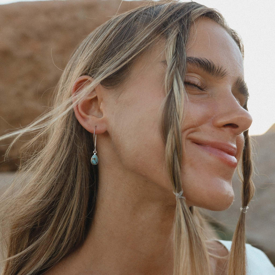 Lady smiling with plaits in her hair wearing Turquoise Earrings - womens turquoise jewellery by indie and harper