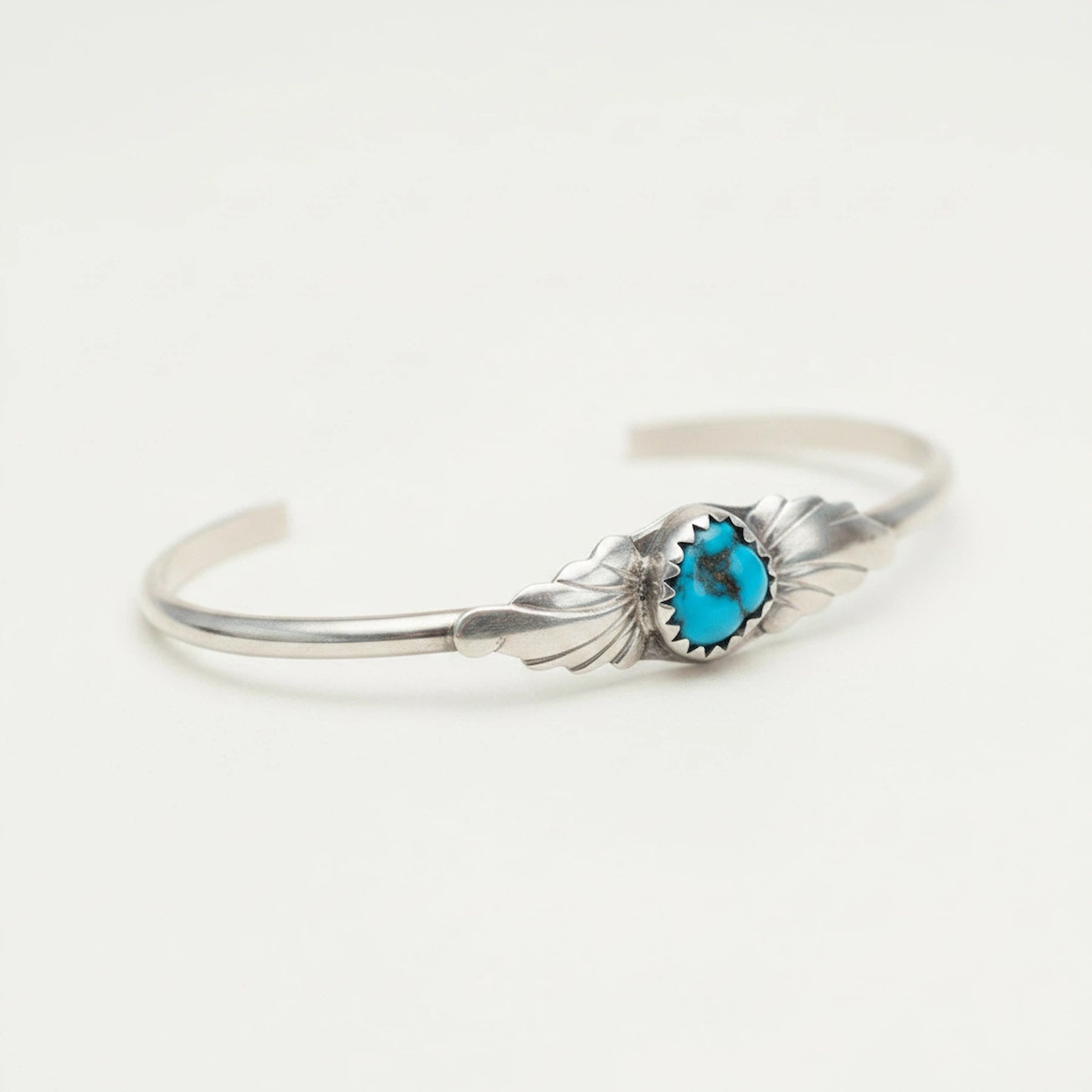 Silver sterling turquoise bracelet with a natural turquoise stone on a white background