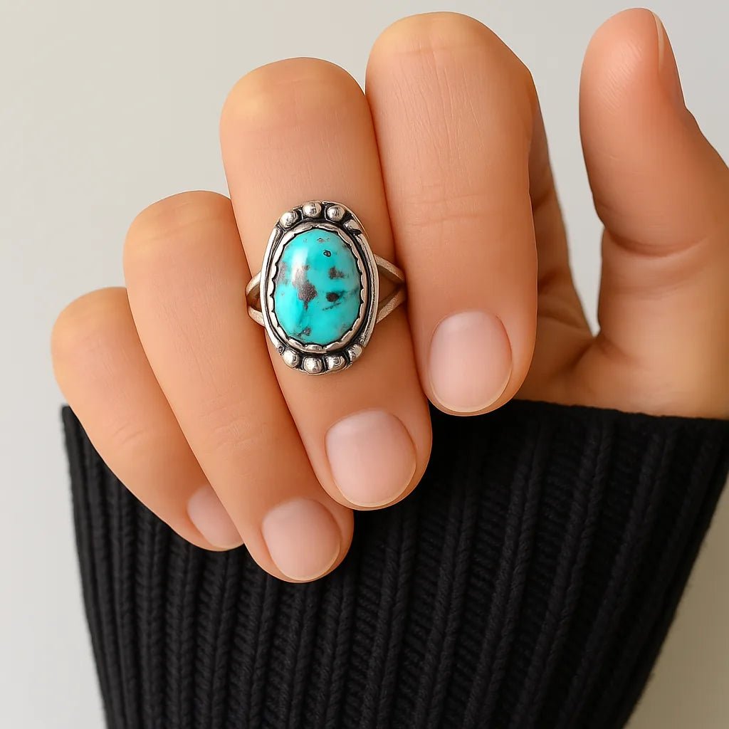 Turquoise ring on a finger with a neutral background