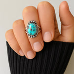 Turquoise ring on a finger with a neutral background