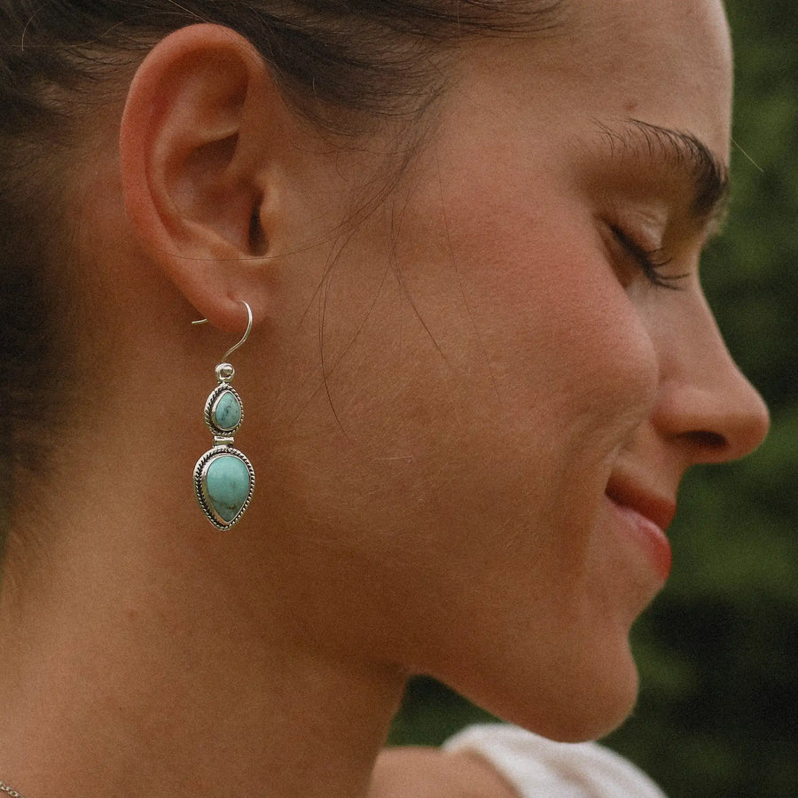 woman wearing sterling silver earrings with two teardrop shaped turquoise stones - turquoise earrings Australia 