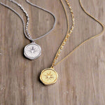 two stainless waterproof necklaces in silver and gold with starburst compass pendants