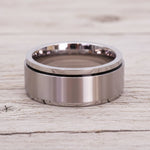 waterproof silver spinner Ring in minimalist stainless steel band design on a light wooden surface
