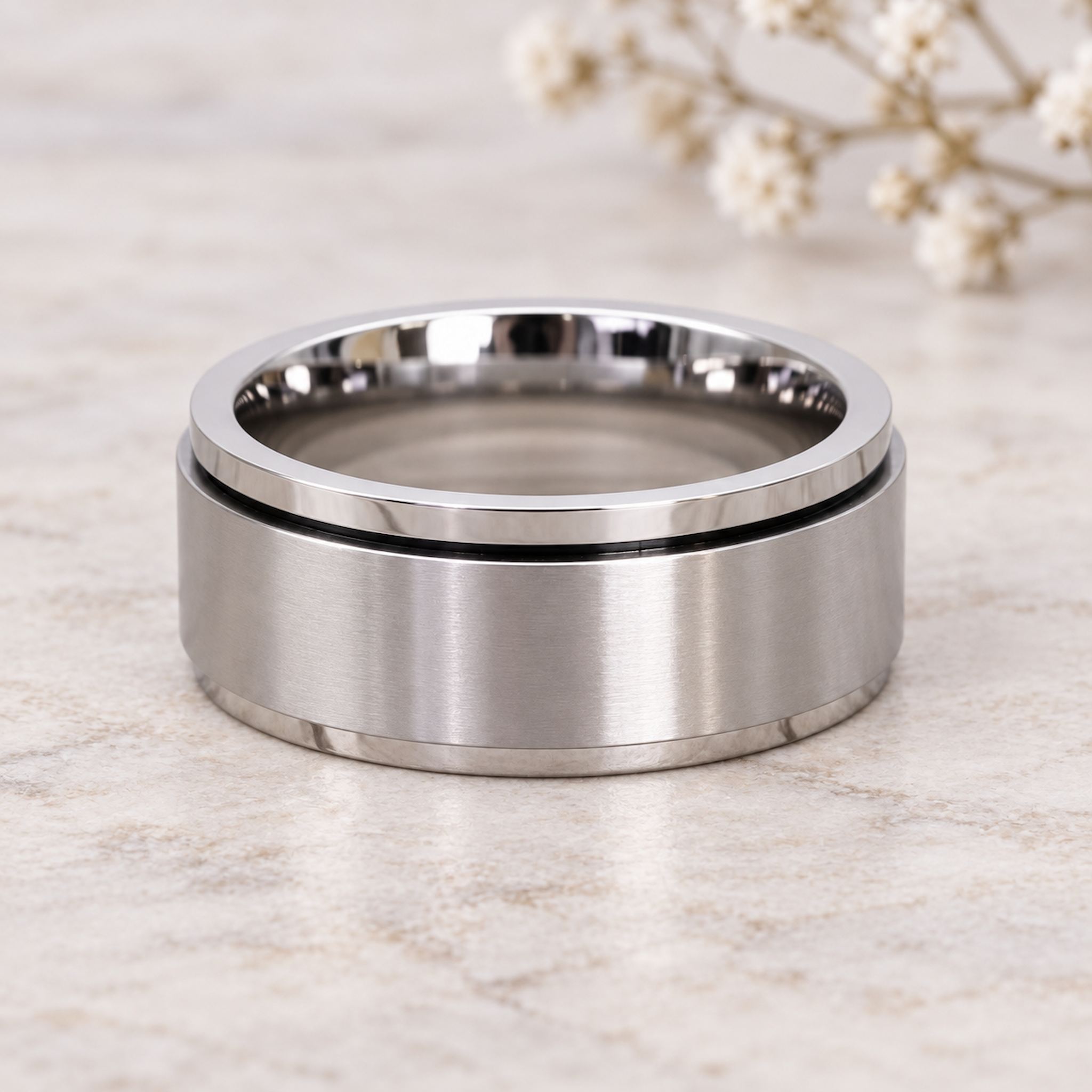 waterproof silver spinner Ring in minimalist stainless steel band design on a light wooden surface