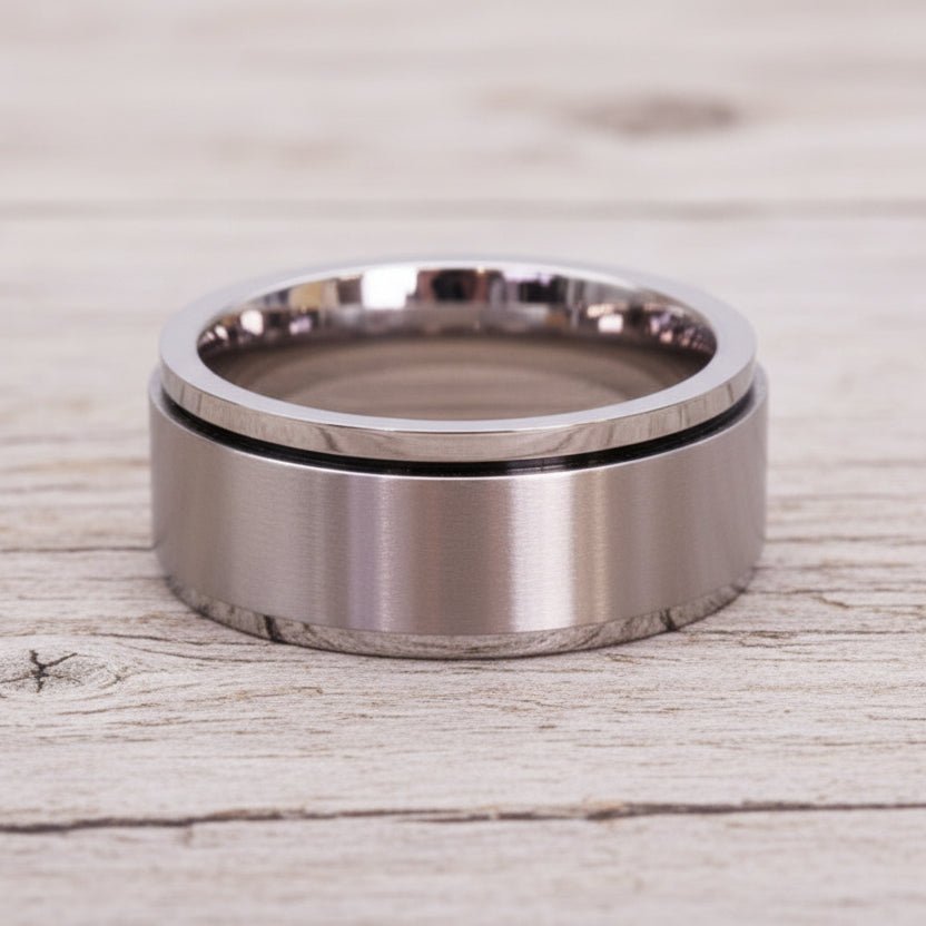 waterproof silver spinner Ring in minimalist stainless steel band design on a light wooden surface