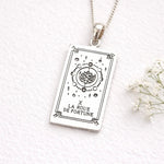 Silver pendant with Wheel of Fortune tarot card design on a white background
