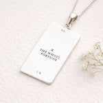 Silver necklace with a rectangular pendant on a white background