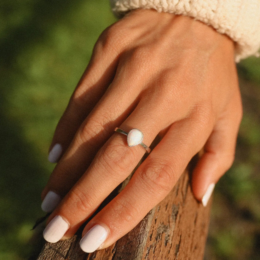 woman wearing a single sterling silver ring with a teardrop shaped opal stone