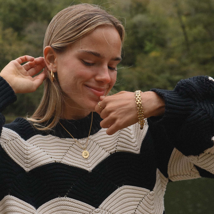 girl wearing black and white striped jumper wearing gold bracelet, gold necklace and gold earrings - womens gold waterproof jewellery - Australian jewellery brand