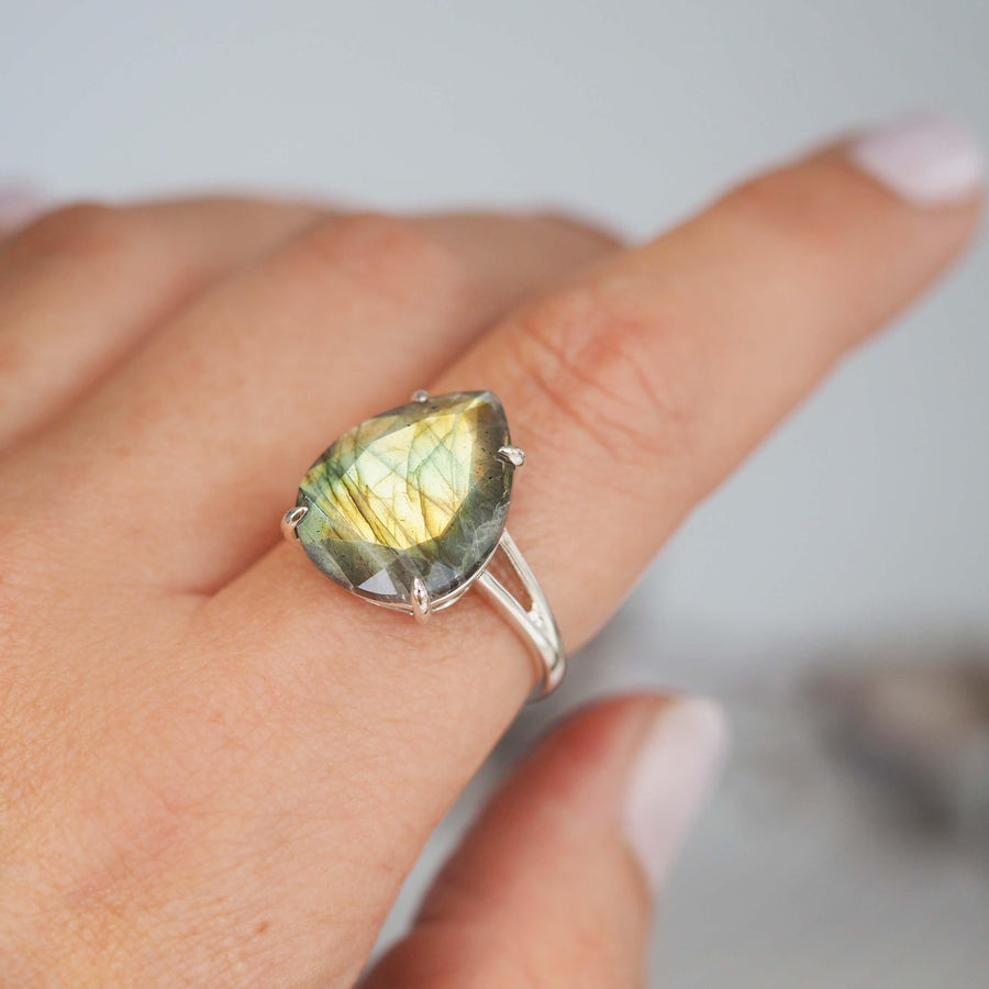 index finger wearing sterling silver ring with faceted labradorite gemstone