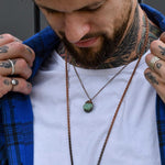 Tattooed man wearing Copper and Raw Emerald Necklace by australian jewellery brands indie and harper 