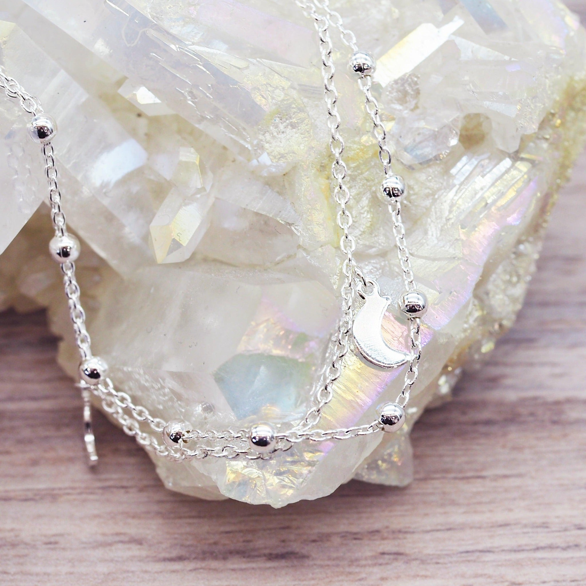 Sterling Silver anklet with small moon charms on a crystal background