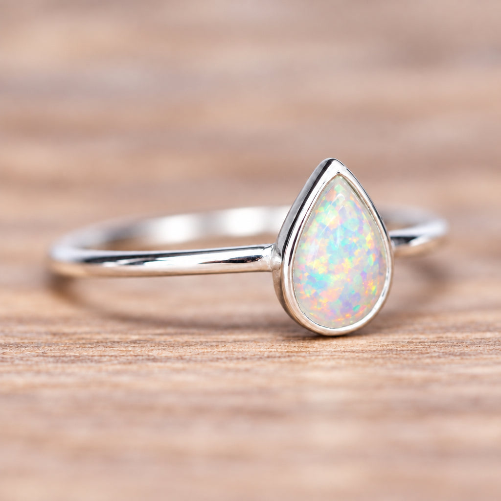 Sterling silver white opal ring from the set on a wooden surface