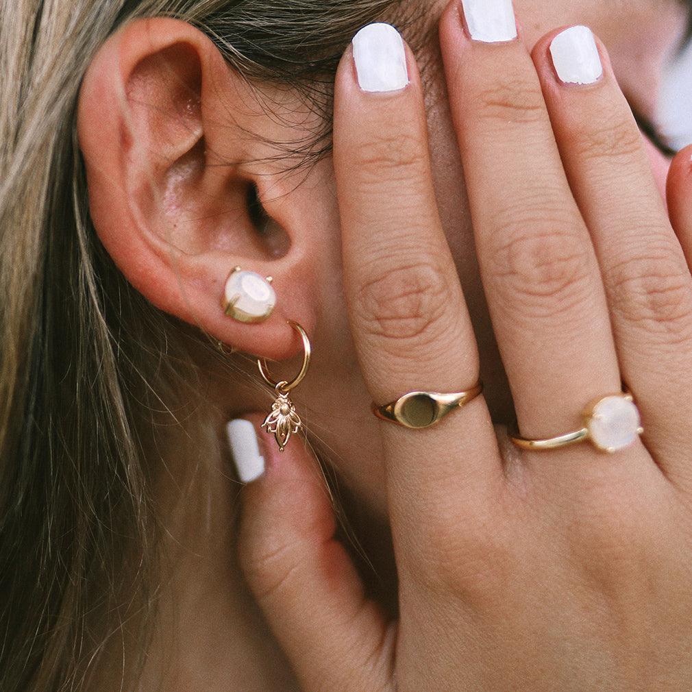 Indie and Harper dainty lotus hoop gold earrings being worn