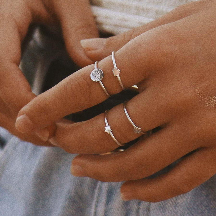 Hand wearing multiple sterling silver rings 