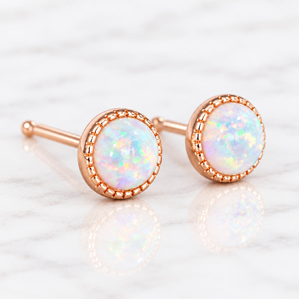 Dainty rose gold white opal stud earrings, close-up