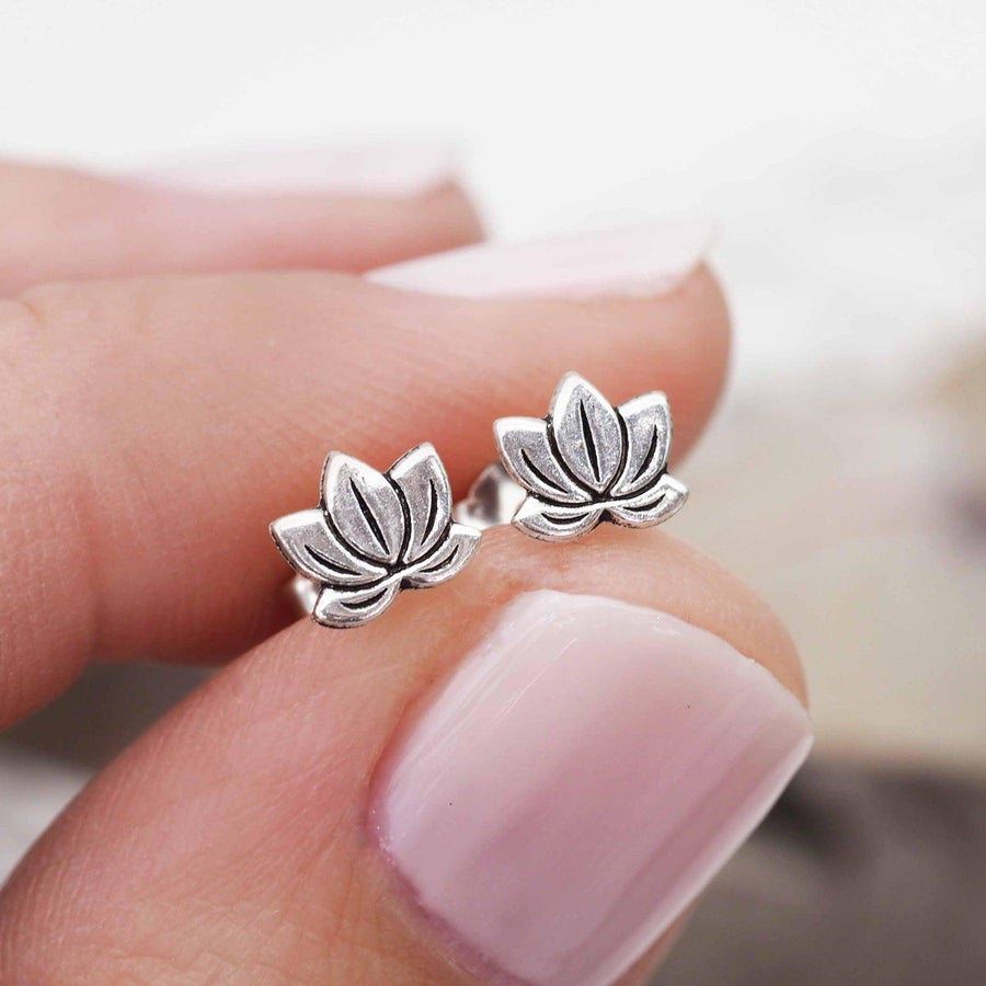 Hand holding Dainty Silver Lotus Stud earrings - womens sterling silver jewellery Australia 