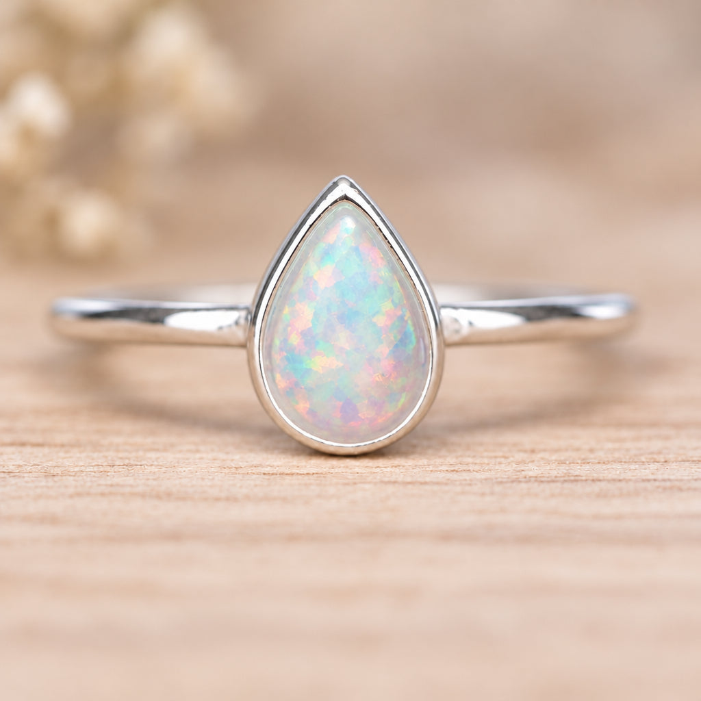 Sterling silver dainty opal ring on a wooden surface