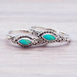 Silver rings with turquoise stones on a light wooden surface
