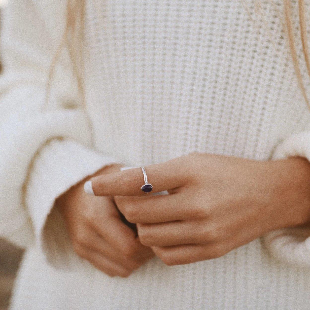 Sterling Silver February Birthstone Ring with a pear-shaped natural amethyst gemstone being worn as a meaningful birthstone jewellery gift for her