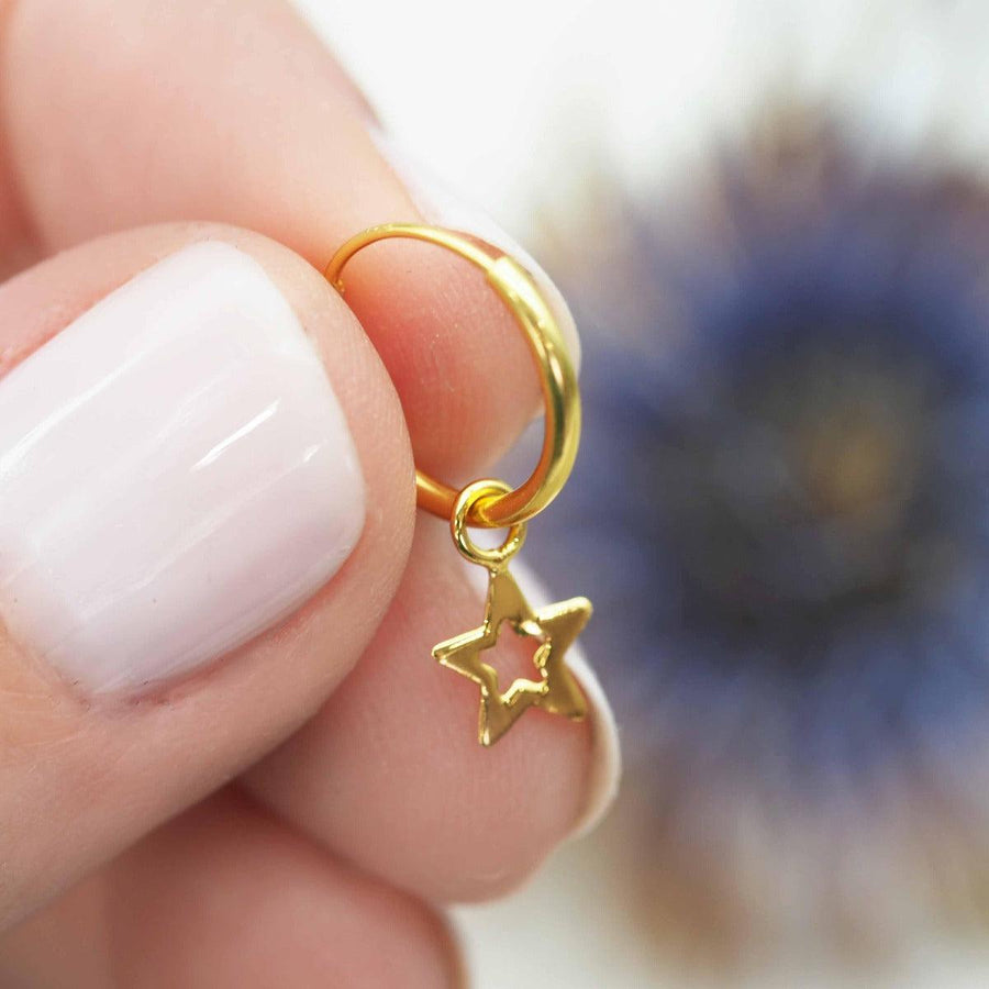 Fingers holding Dainty star Gold earrings - womens gold jewellery Australia