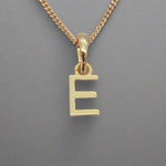 gold initial e necklace on grey background
